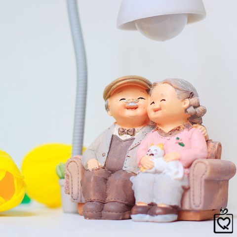 Statue of grandparents - hugging a cat confiding under the lamp